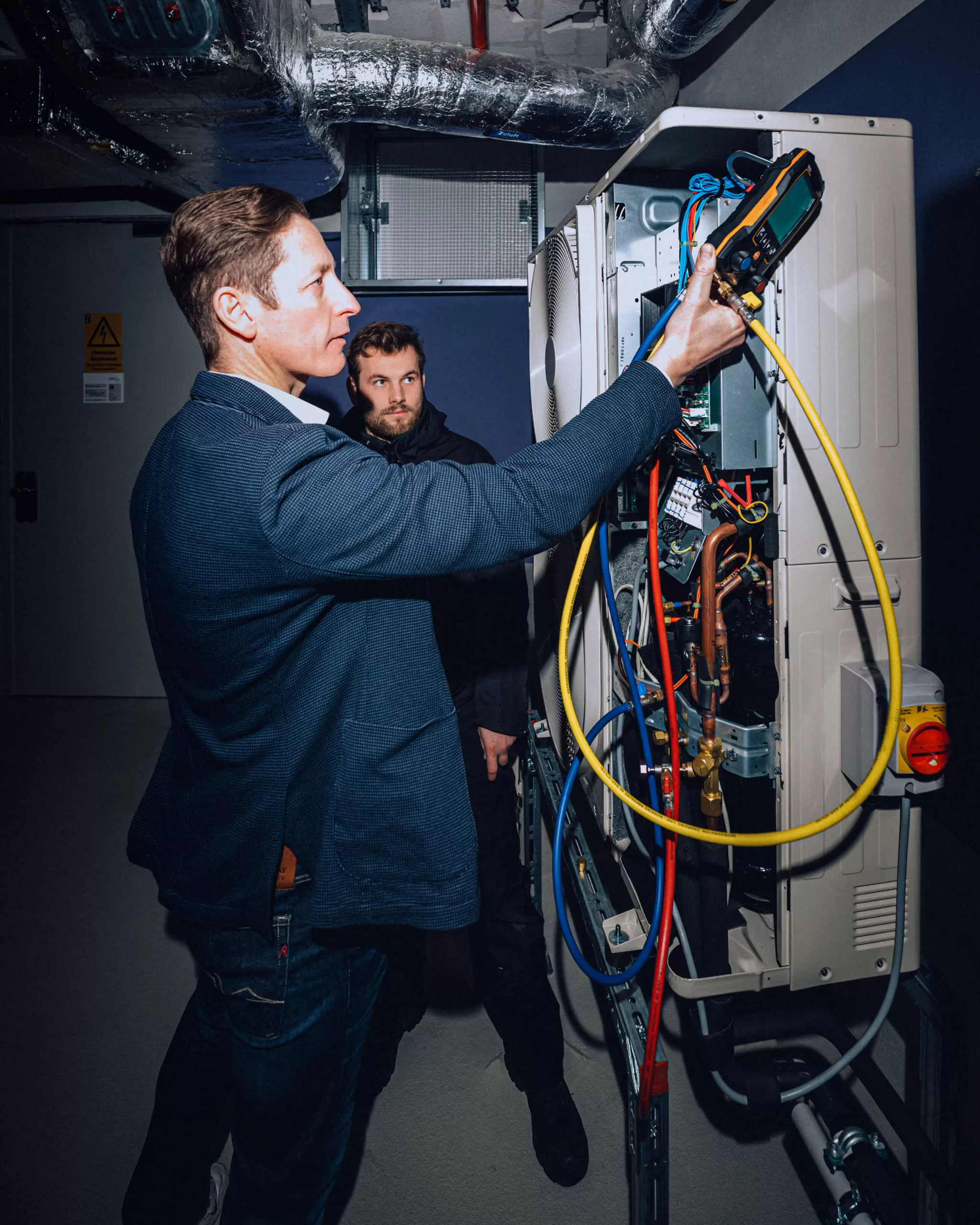 Zwei Mitarbeiter der Firma Stay Cool Kälte- und Klimatechnik bei der Wartung eines Betriebssystems eines Kunden.